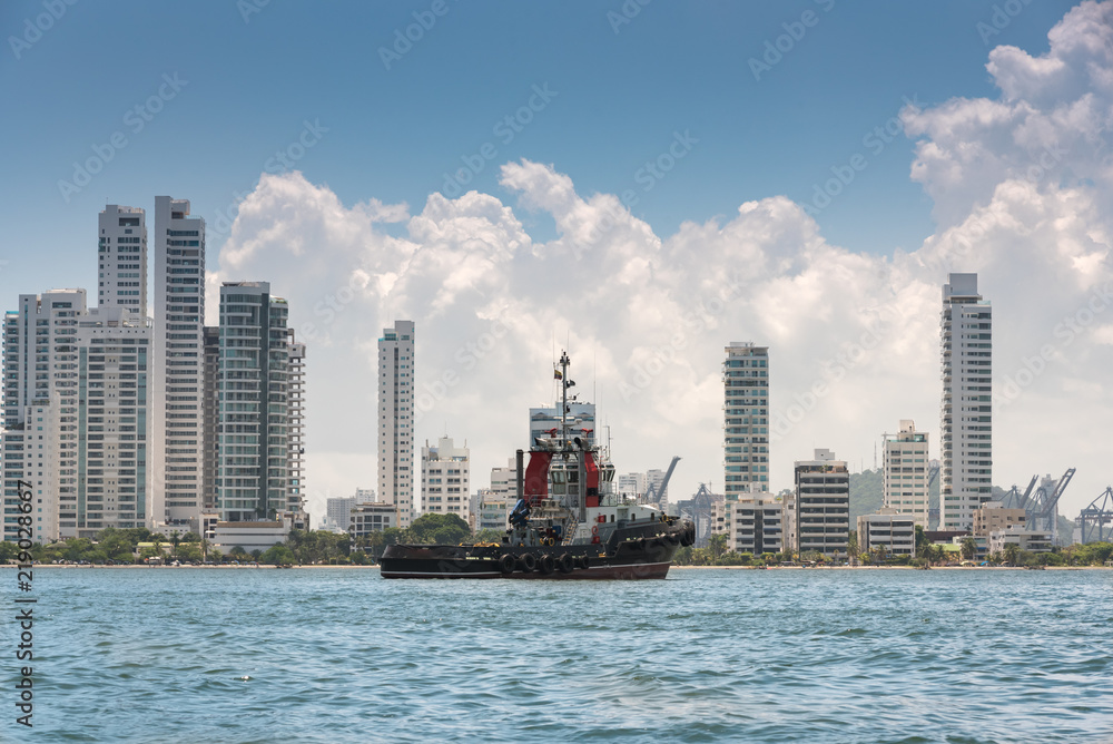 tugboat in the bay of Cartagena with modern city background. Colombia
