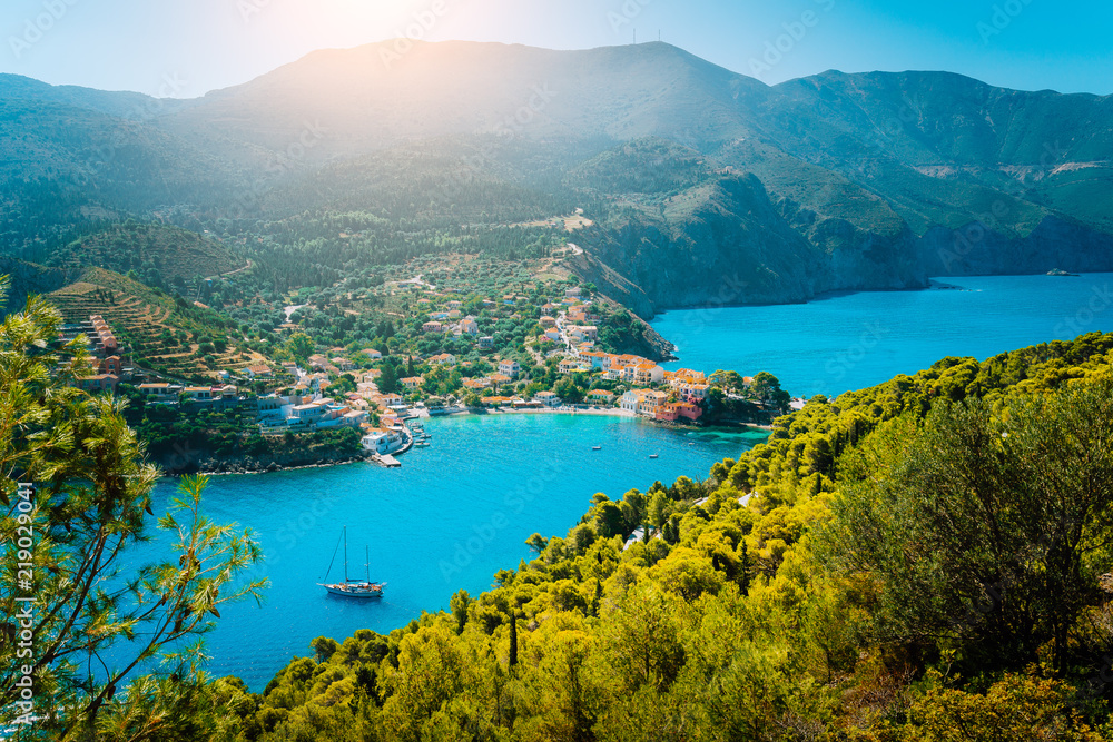 Top view to Assos village Kefalonia. Greece. Beautiful turquoise colored bay lagoon water surrounded by pine and cypress trees along the coastline