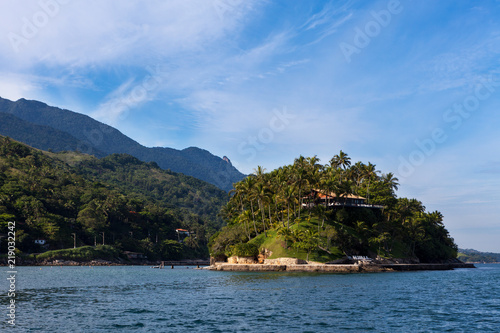 Panoramic view with island, mountain and blue sky on sunny summer day in Ilha Bela on the coast of São Paulo, Brazil.