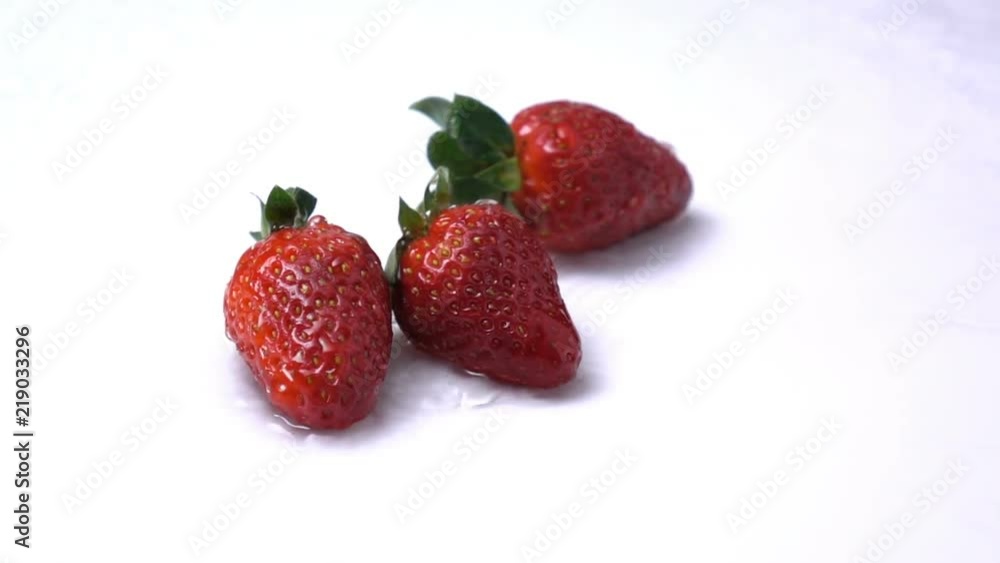 water splashing on a strawberry fruit in slow motion. water splashing on a strawberry fruit in slow motion.