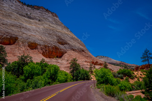 Beautiful view of red asphalt scenic road among the picturesque mountains of orange and red sandstone