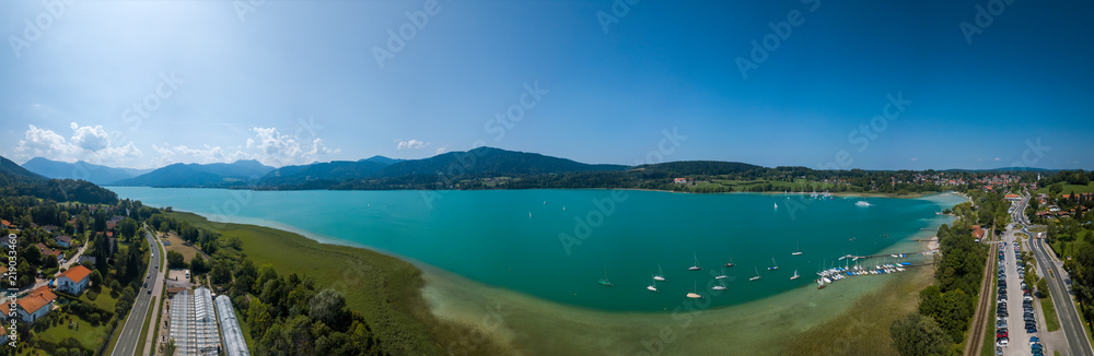 View over the beautiful turquoise Tegernsee in the southern Bavaria as an wide aerial panorama made by a drone, up in the sky