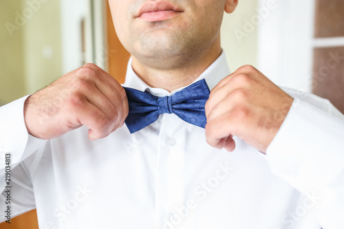 groom wears a tie before wedding ceremony