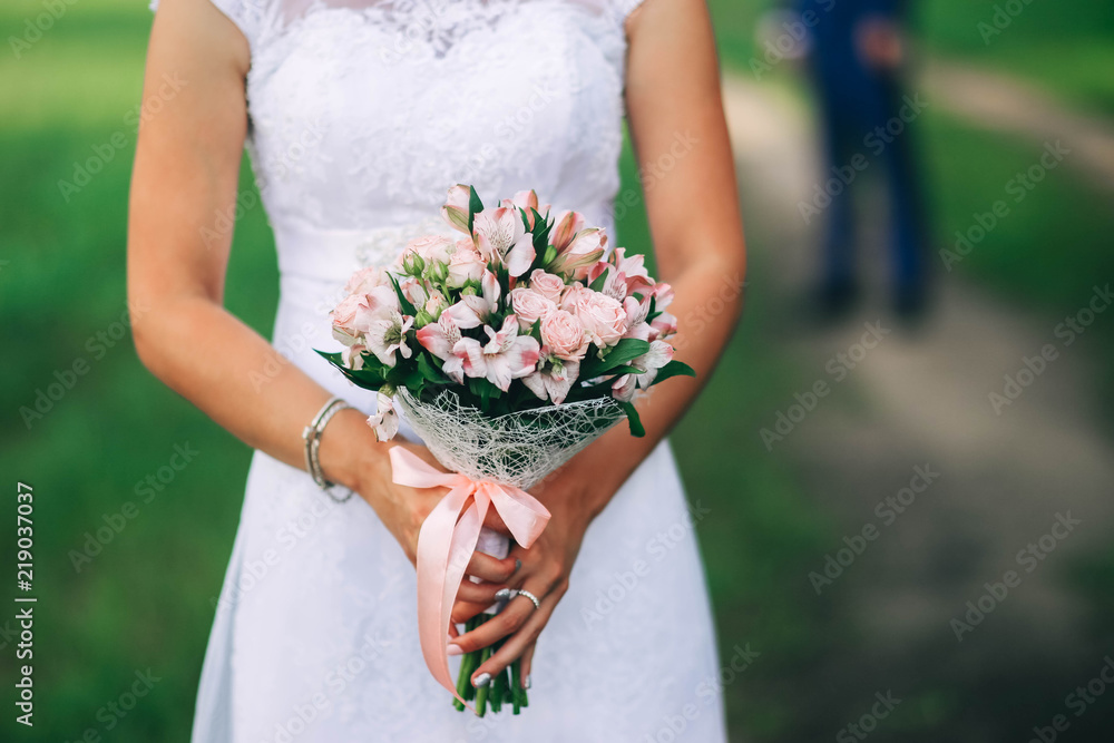 wedding bouquet with roses and a lacy white dress. wedding bouquet with roses and a lacy white dress.