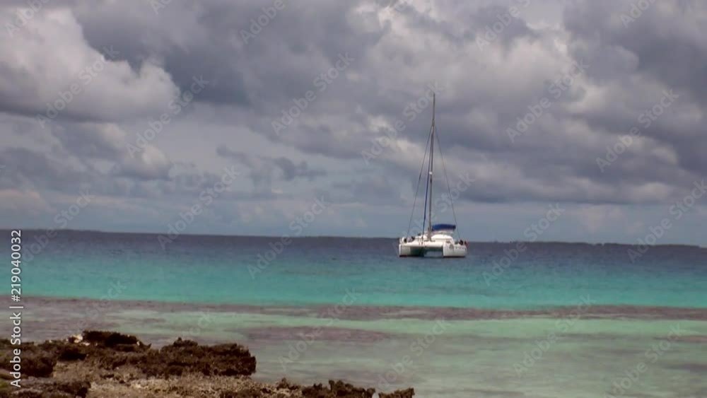 White catamaran in ocean. Picturesque wild nature of French Polynesia Tahiti Island and beautiful landscape. White catamaran in ocean. Picturesque wild nature of French Polynesia Tahiti Island and beautiful landscape.