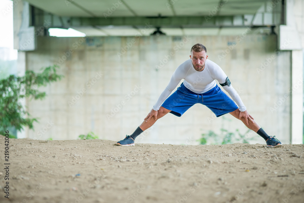 Young man stretches before his workout