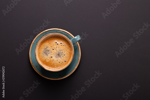 Cup of coffee on black background. Copy space. Top view. Flat lay.