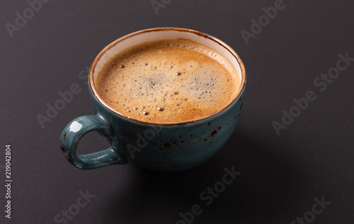 Cup of coffee on black background. Copy space. Top view. Flat lay.