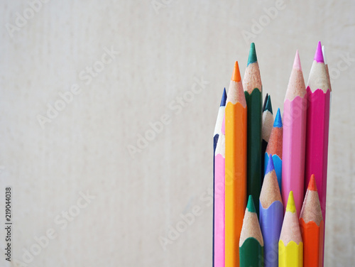 Different colored pencil in bundle on a wooden background with free space for copy text or advertisement