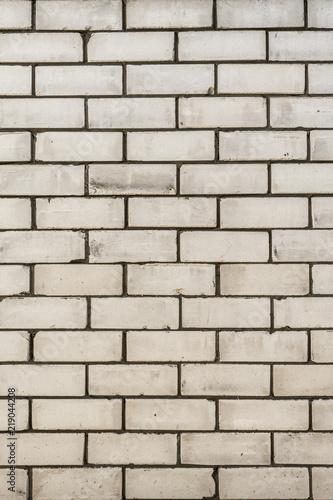 texture of a wall from a natural white brick with small cracks and chips, close-up abstract background