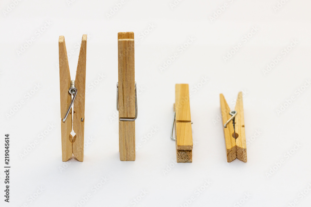 Isolated wooden clothes pegs standing and lying side by side on a white background Isolated wooden clothes pegs standing and lying side by side on a white background
