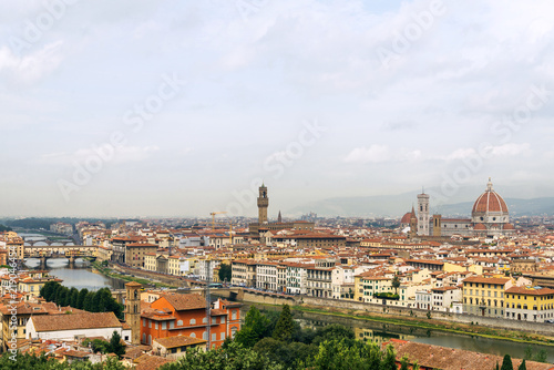 Top panoramic view of old town Florence city, riverside of Arno river, Ponte vecchio bridge and Cathedral of Santa Maria del Fiore during and cloudy sky from Piazzale Michelangelo in Florence, Italy.