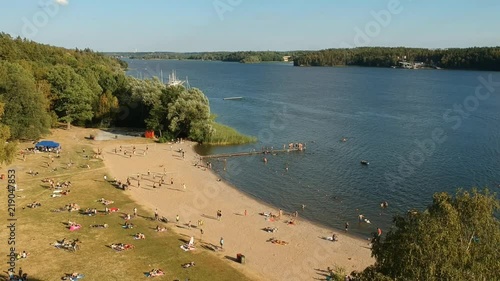 A beach in Stockholm at afternoon with several people, who are enjoying the summer. photo