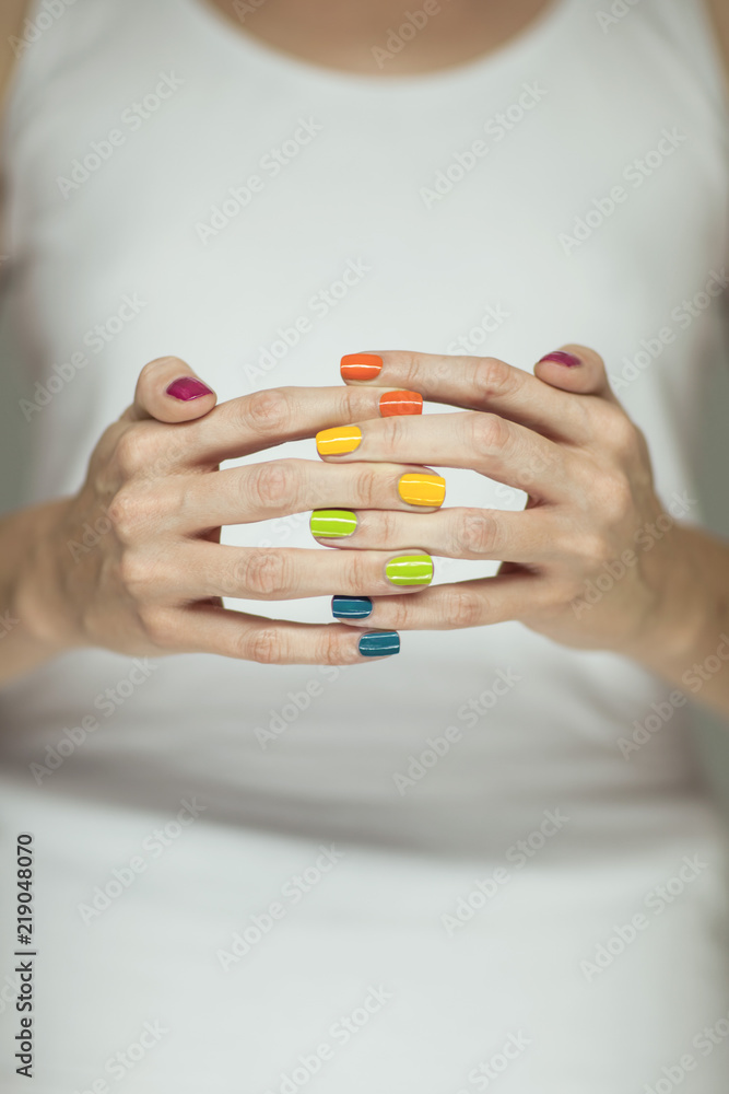 Beautiful woman hands with colorful rainbow nail polish, can be used as background Beautiful woman hands with colorful rainbow nail polish, can be used as background