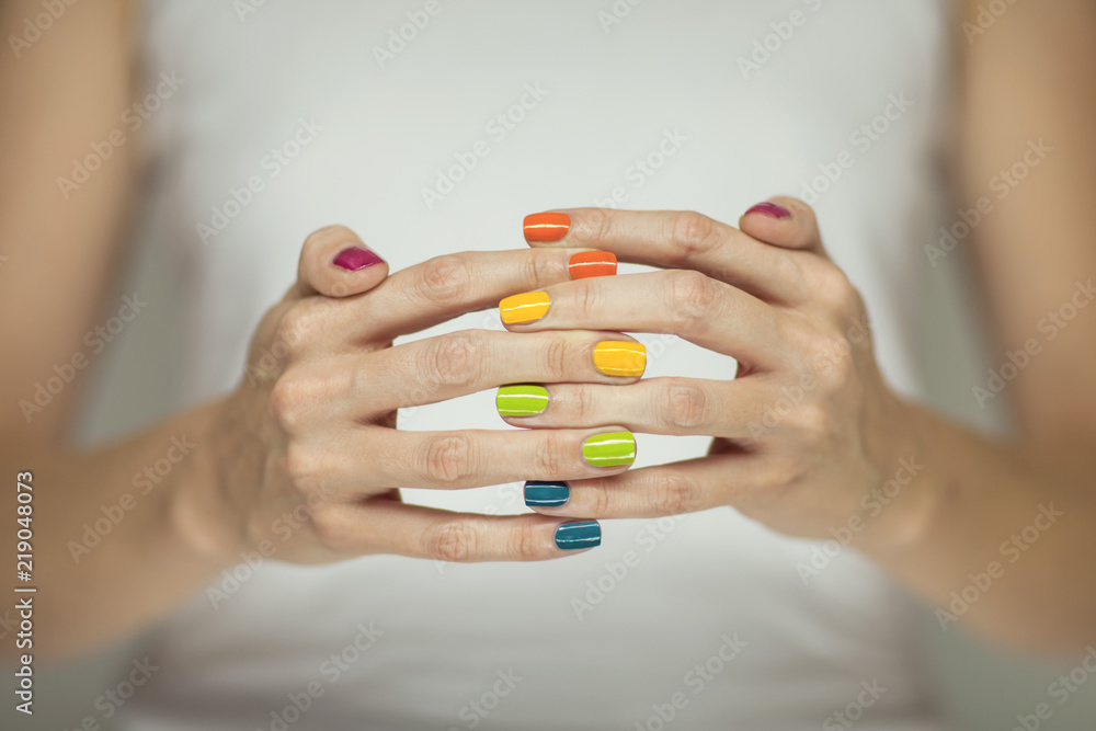 Beautiful woman hands with colorful rainbow nail polish, can be used as background Beautiful woman hands with colorful rainbow nail polish, can be used as background