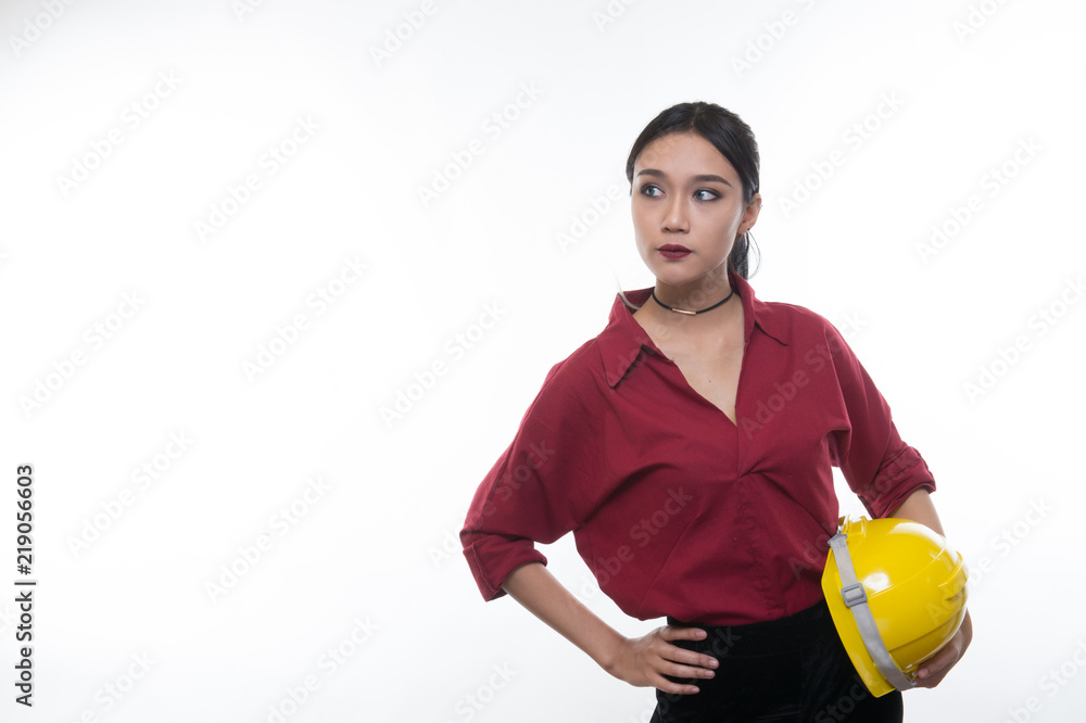 Beautiful engineering woman holding helmet in red shirt and yellow helmet with white background. Beautiful engineering woman holding helmet in red shirt and yellow helmet with white background.