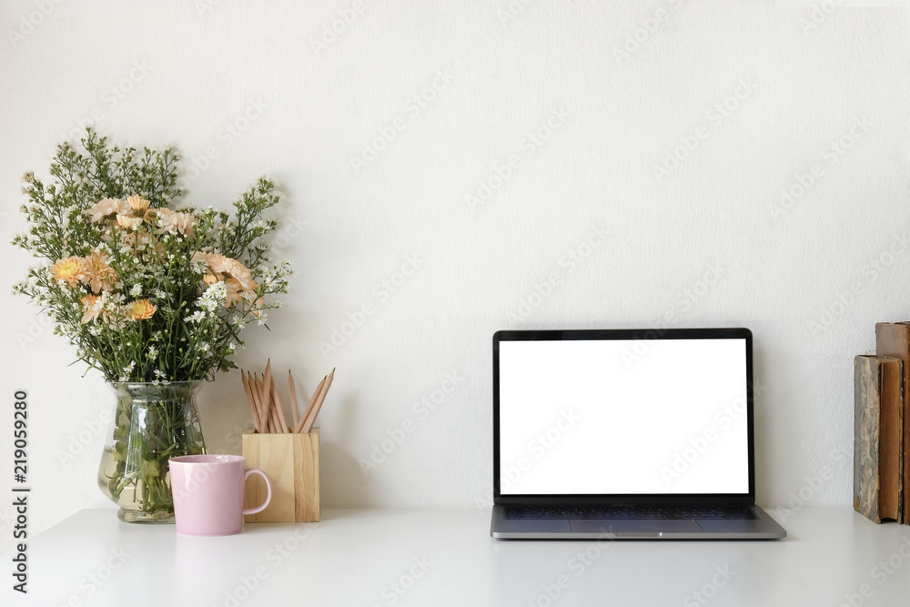 Desktop of female designer Mock up laptop and table of creative with nobody. Beautiful flower bouquet and coffee mug with pencil and sticky note. Desktop of female designer Mock up laptop and table of creative with nobody. Beautiful flower bouquet and coffee mug with pencil and sticky note.