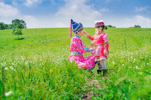 Mother and daughter dressed in Mongolian costumes on the grassland
