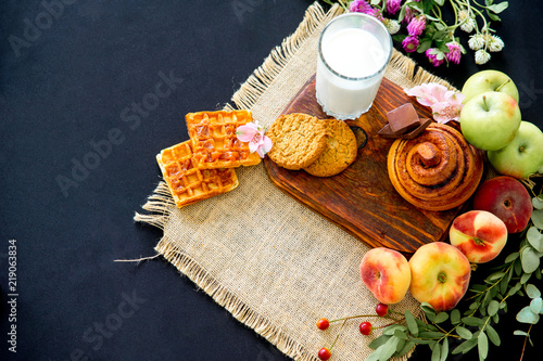 Homemade cinnamon buns in glaze on a dark plate with berries photo