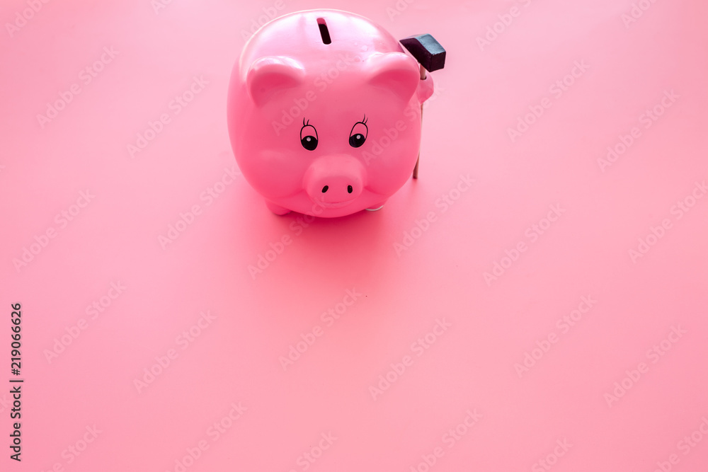 Piggy bank. Moneybox in shape of pig near hammer on pink background copy space