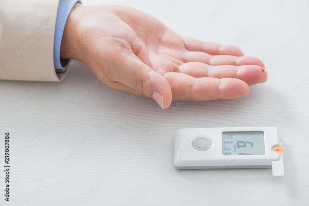 man measures sugar level with a glucometer man measures sugar level with a glucometer