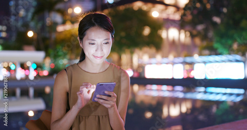 Photography Woman use of smart phone in city at night