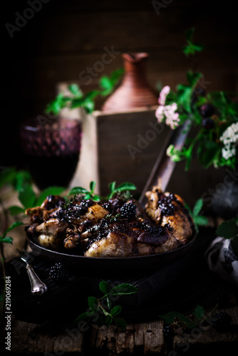 Quail with blackberry sauce.darck rustic photo