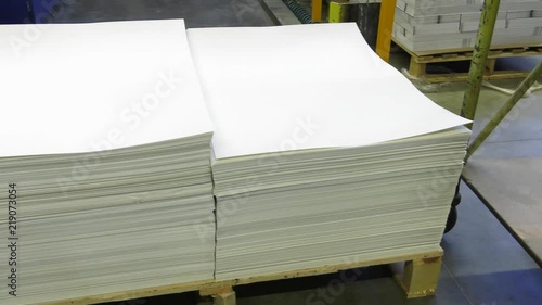 Big sheets of paper lie on a pallet. Panning the camera.