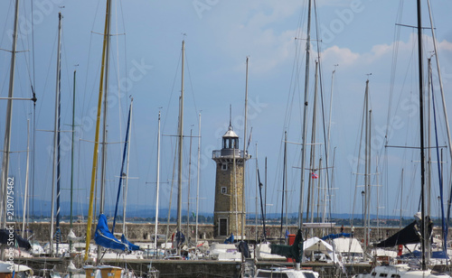 faro nel porto con alberi di imbarcazioni a vela ormeggiati photo