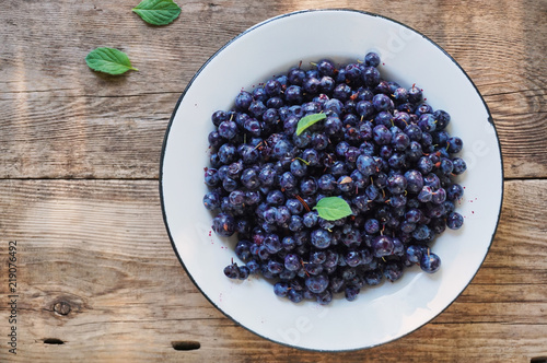 Fresh blueberries in a bowl on a wooden background