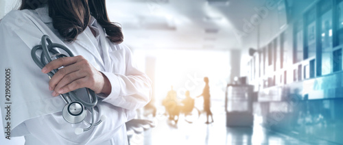 Female doctor in confident with stethoscope in hand on hospital background photo