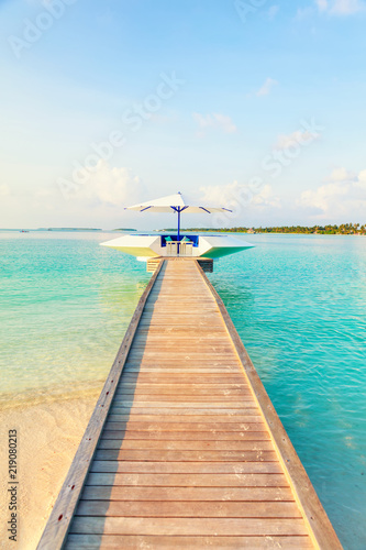 Wooden pier, jetty at tropical island resort in early morning, Maldives. Vacations And Tourism Concept © 18042011