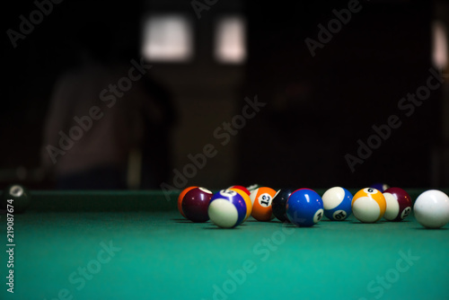 Sport billiard balls on green billiard table in pub. On going billiard game. Competitive players trying to find out the winner of the round