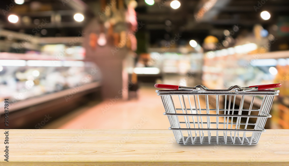 Empty Shopping basket on wood table over grocery store supermarket blur background Empty Shopping basket on wood table over grocery store supermarket blur background