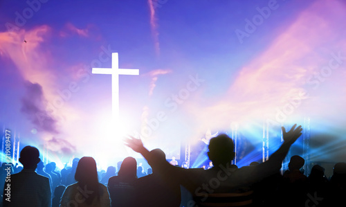 Worship and praise concept: Silhouette many people raised hands over sunset background photo
