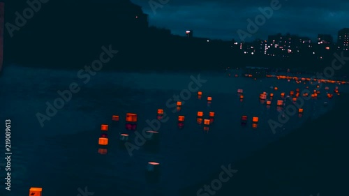 Hundreds of Asian colorful lanterns floating on the waterfront people wishing ancestors peace photo