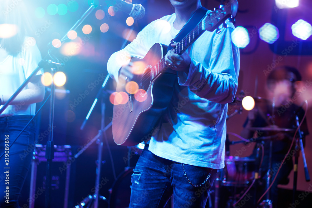 Obraz premium Guitarist on stage with lighting for blackground. Guitar player, soft and blur concept.