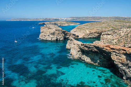 Comino, Malta - Comino island of the Maltese archipelago between the islands of Malta and Gozo in the Mediterranean Sea. Bright blue sea with some rocky islets in it. 