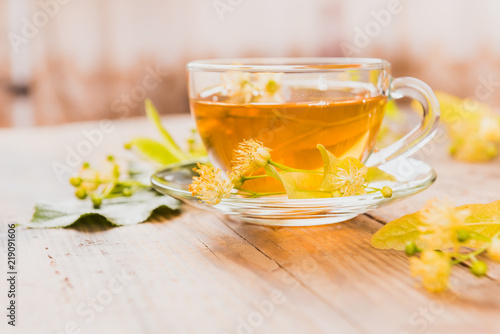 Cup of tea and linden on wooden background