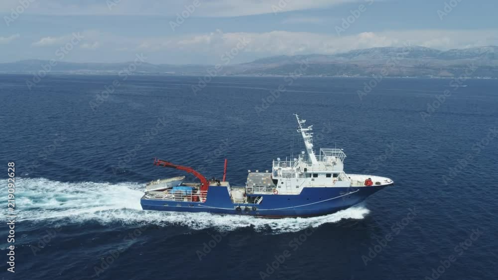 Aerial shot of fishing boat cruising at sea - July 2018: Adriatic sea, Croatia