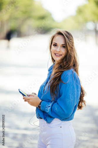 Young beautiful woman with smartphone outdoor in the street. lifestyle portrait