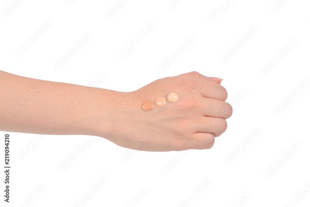 Fair, medium, dark swatches  of foundation on the hand isolated on white.