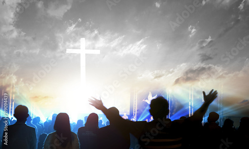 Worship and praise concept: Silhouette many people raised hands over sunset background