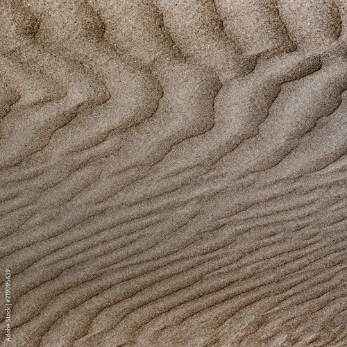Sand background. Top view of sandy. Background wiht copy space and visible sand texture. Fine sand. Pattern on the sand.