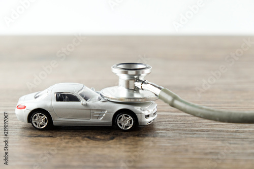 Stethoscope checking up the car on wooden table, Concept of car check up, repair and maintenance..