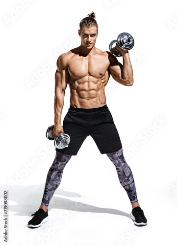 Strong man doing exercise with heavy weight dumbbells. Photo of young man with good physique isolated on white background. Strength and motivation. Full length