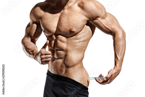 Bodybuilder makes an injection of vitamins. Photo of sporty man with perfect physique showing gesture like thumb up on white background. Close up. Strength and motivation
