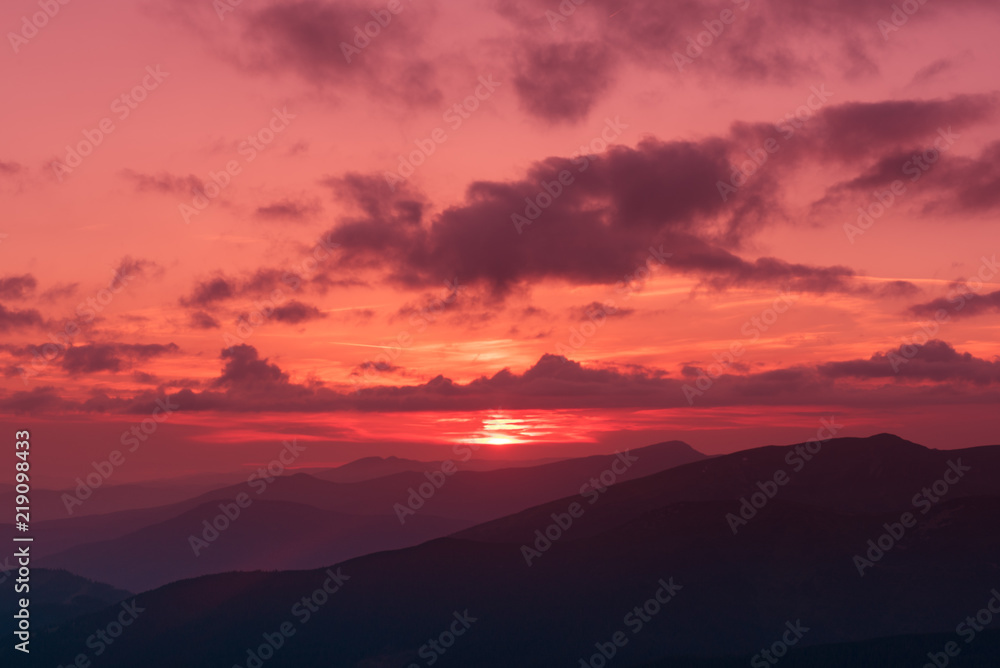 Amazing mountain landscape with colorful vivid sunset on the bright sky, natural outdoor travel background