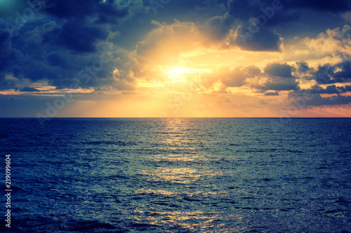 Beautiful bright colorful stunning sea sunset, rays of the sun in the clouds dramatic sunset over the ocean