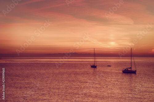 Beautiful colorful sunset at the sea with two sailing boats . Beauty world natural outdoors travel background © Roxana